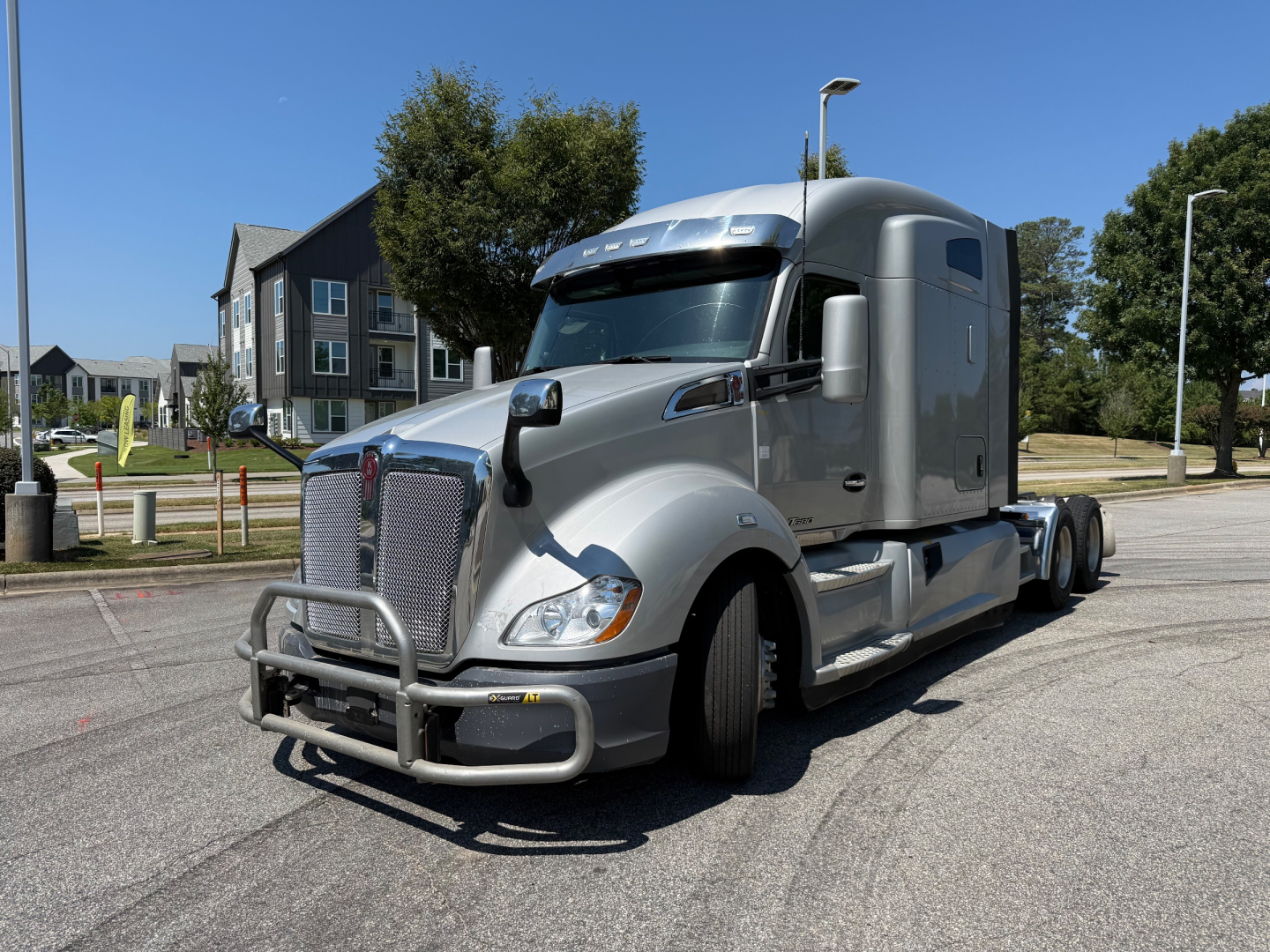 Kenworth T680 semi truck in silver showing front grille guard and side view mirrors.
