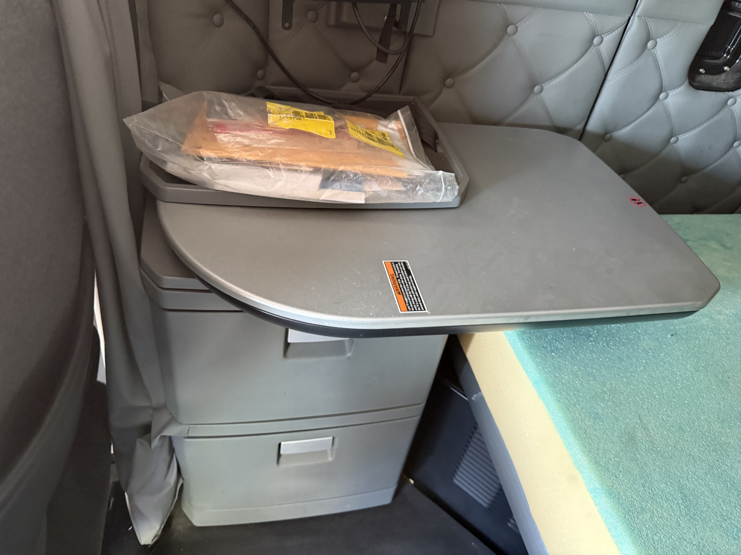 Kenworth T680 cab interior showing sleeper compartment and storage drawer with a folded item on top.