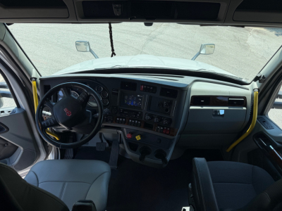 Kenworth T680 cab interior showing steering wheel, dashboard, and center console with gauges and controls.