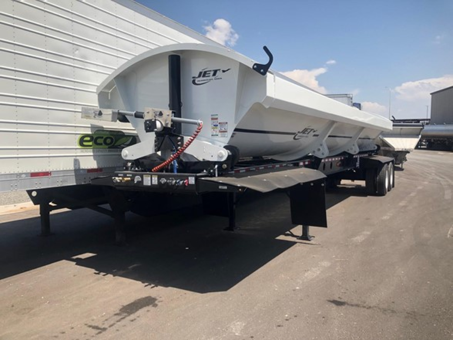 Jet 40' air ride side dump trailer on dual-axle trailer with hydraulic hoses and hitch, white with Jet logo.