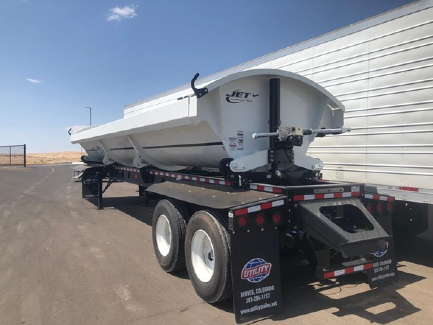 Jet 40' air ride side dump trailer on dual axle with white body and black chassis, logo 'JET' on side, mounted on trailer bed.