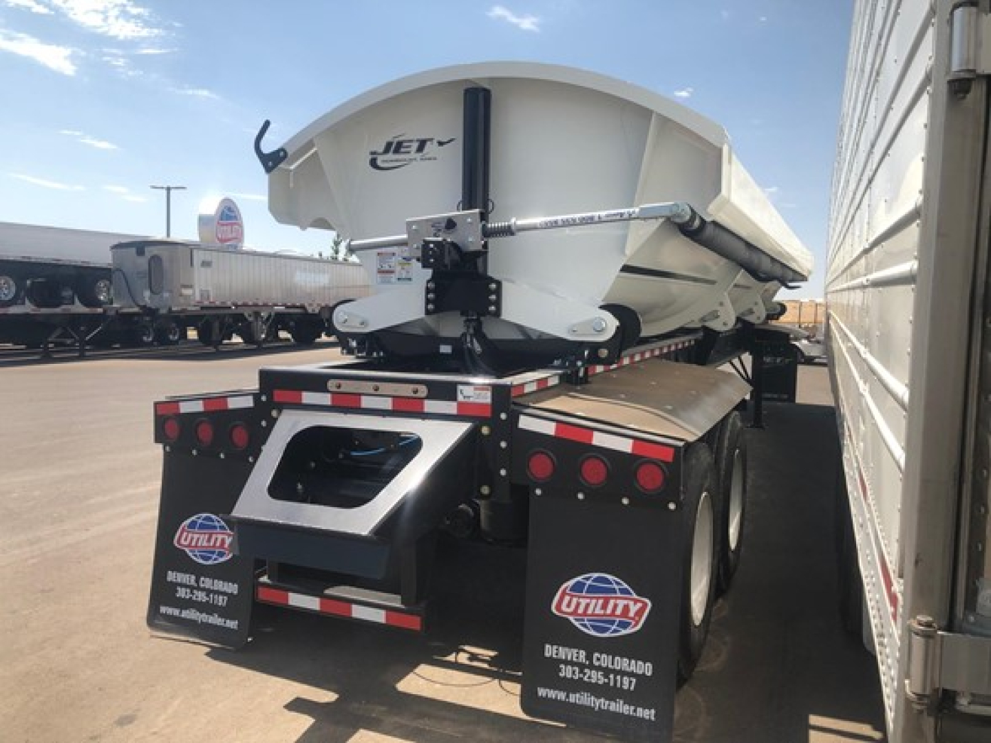 Jet 40' air ride side dump trailer viewed from rear side, with Jet logo on upper hopper and Utility trailer decals on rear gates.