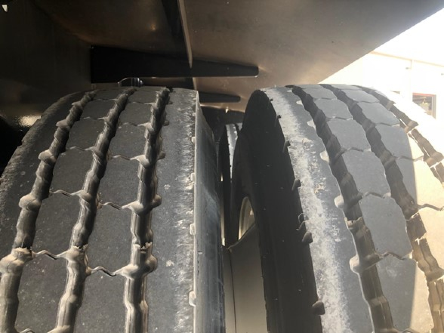 Dual rear tires of a new 2026 Jet Jet 40' air ride side dump trailer, tread visible with road grime.