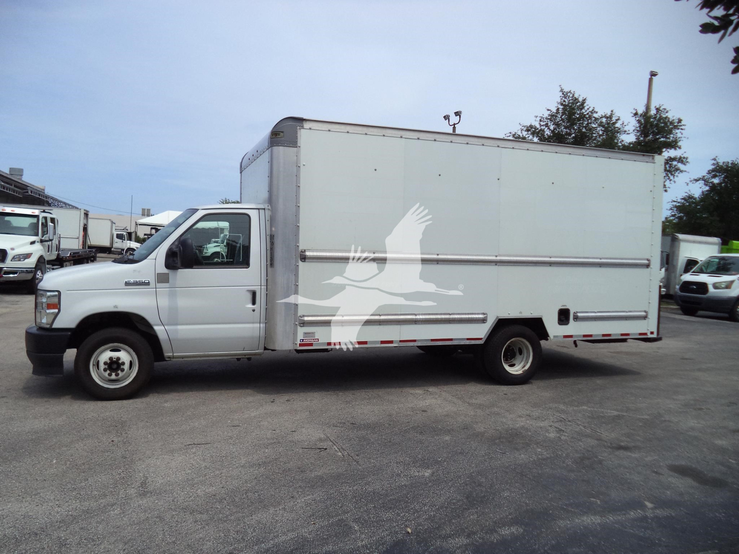 Ford E-Series cutaway box truck in side view with light gray cargo box, cab, and registration details. Visible text includes VIN 1FDWE3FN6NDC03440, stock T03440, category High Cubes / Cutaways, type Trucks, condition Used, model year 2022.