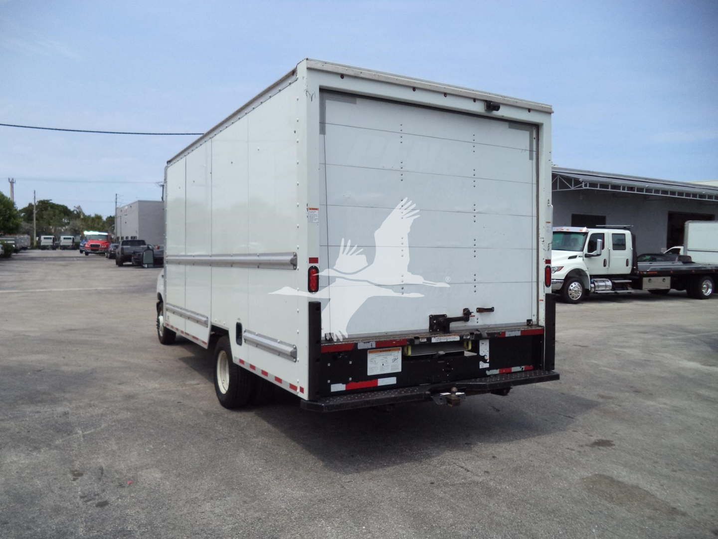Ford E-350 box truck rear view with cargo box and rear doors, white with a decorative bird graphic on the back doors.