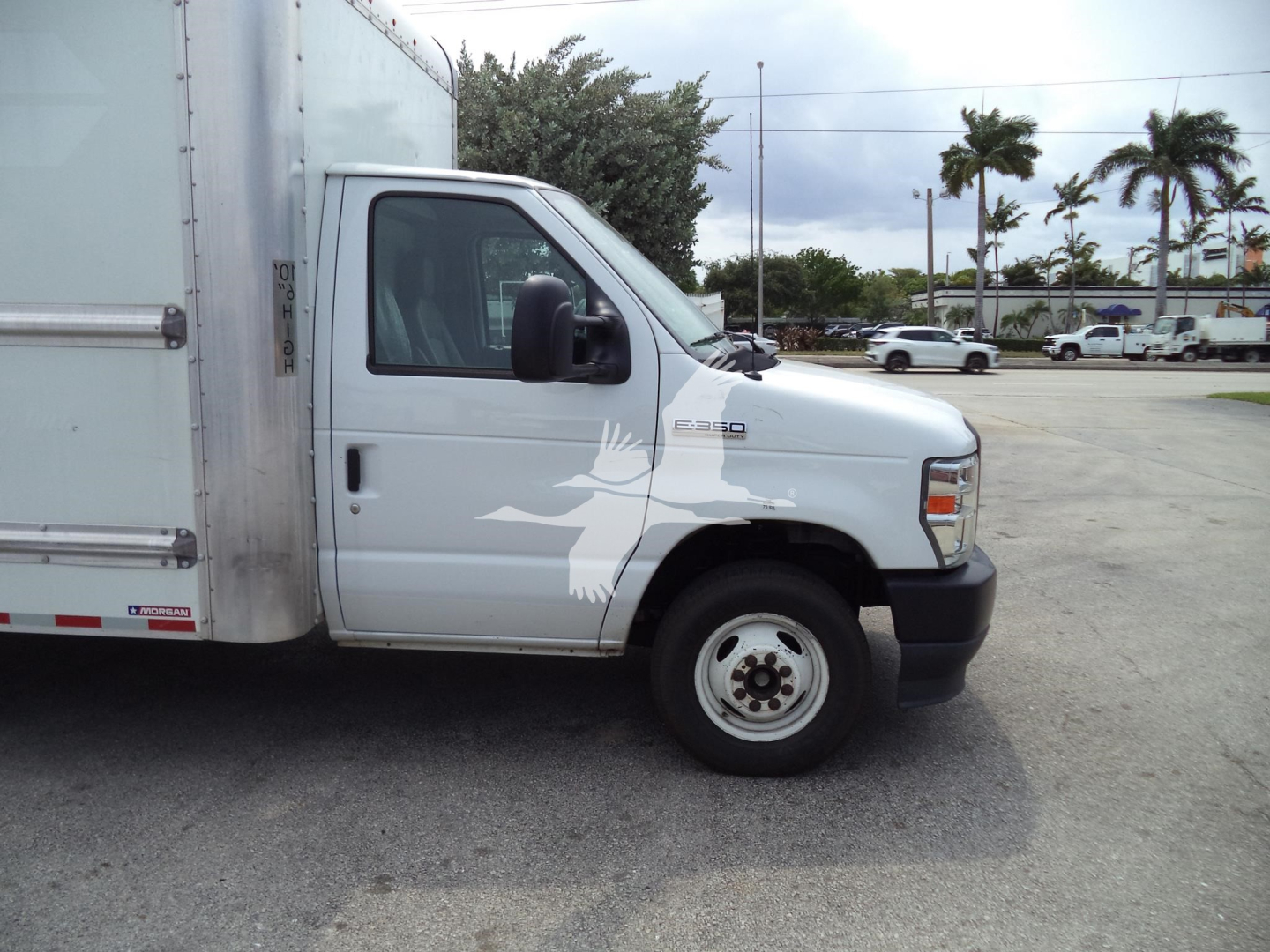 Ford E-350 cutaway box truck side view showing cab and cargo box with E350 badge and white exterior.