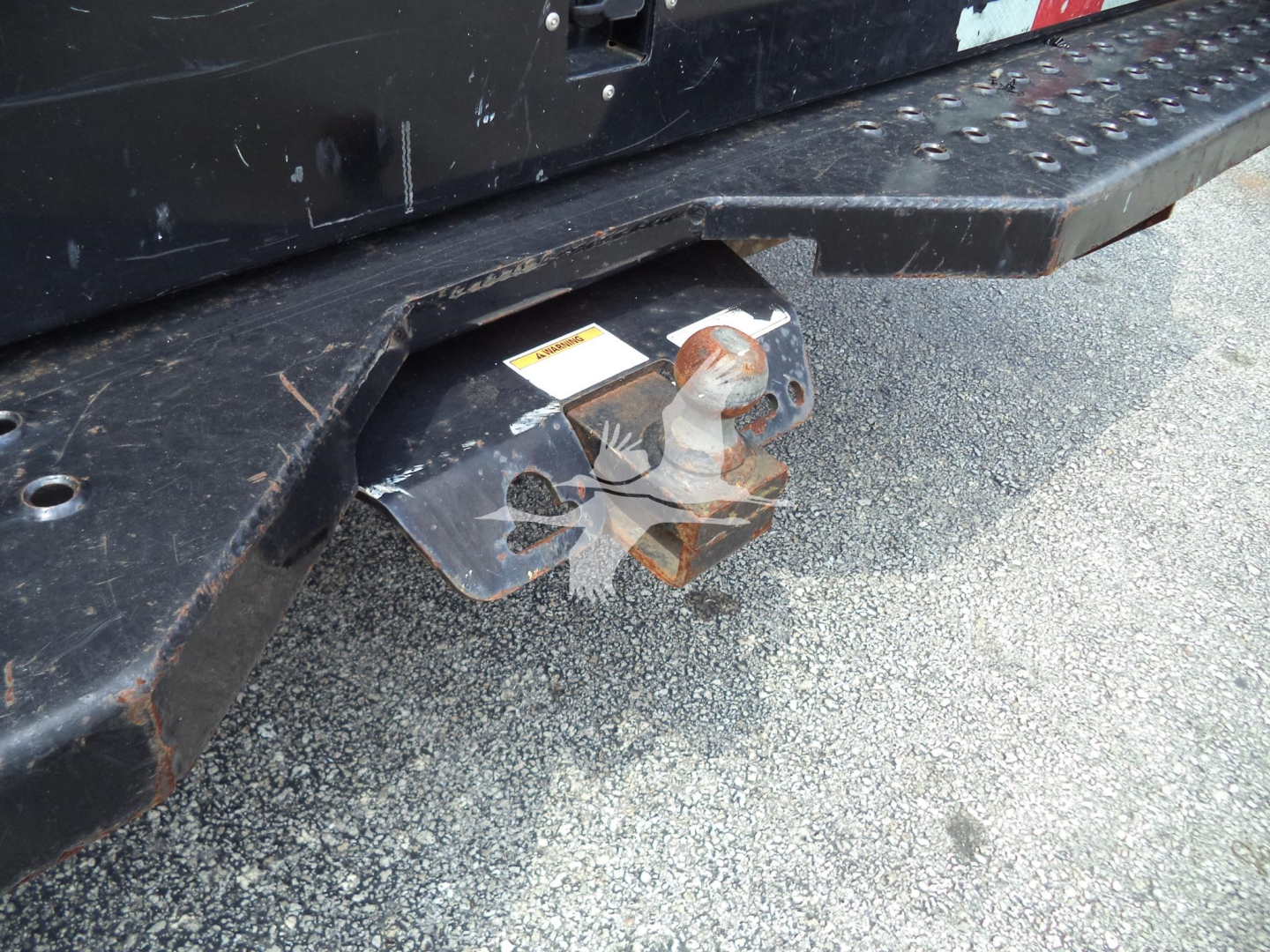 Truck rear hitch with trailer hitch ball and step bumper visible on a Ford E350 rear.