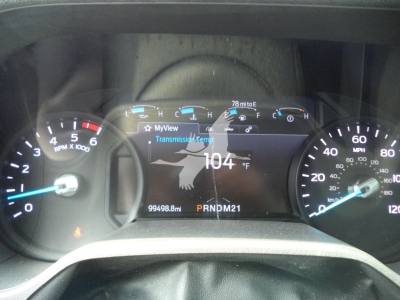 Vehicle dashboard cluster showing digital readout with 104°F temperature, 99498.8 miles, transmission temp, and gear indicator P R N D M 2 1.