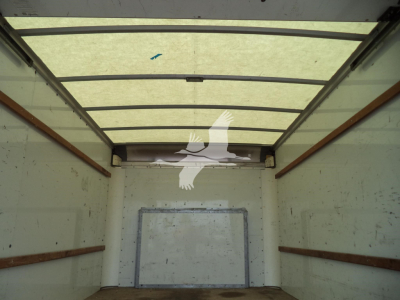 Truck cargo area interior showing empty box with metal walls and rear doors in a Ford E350 high cube cargo van.