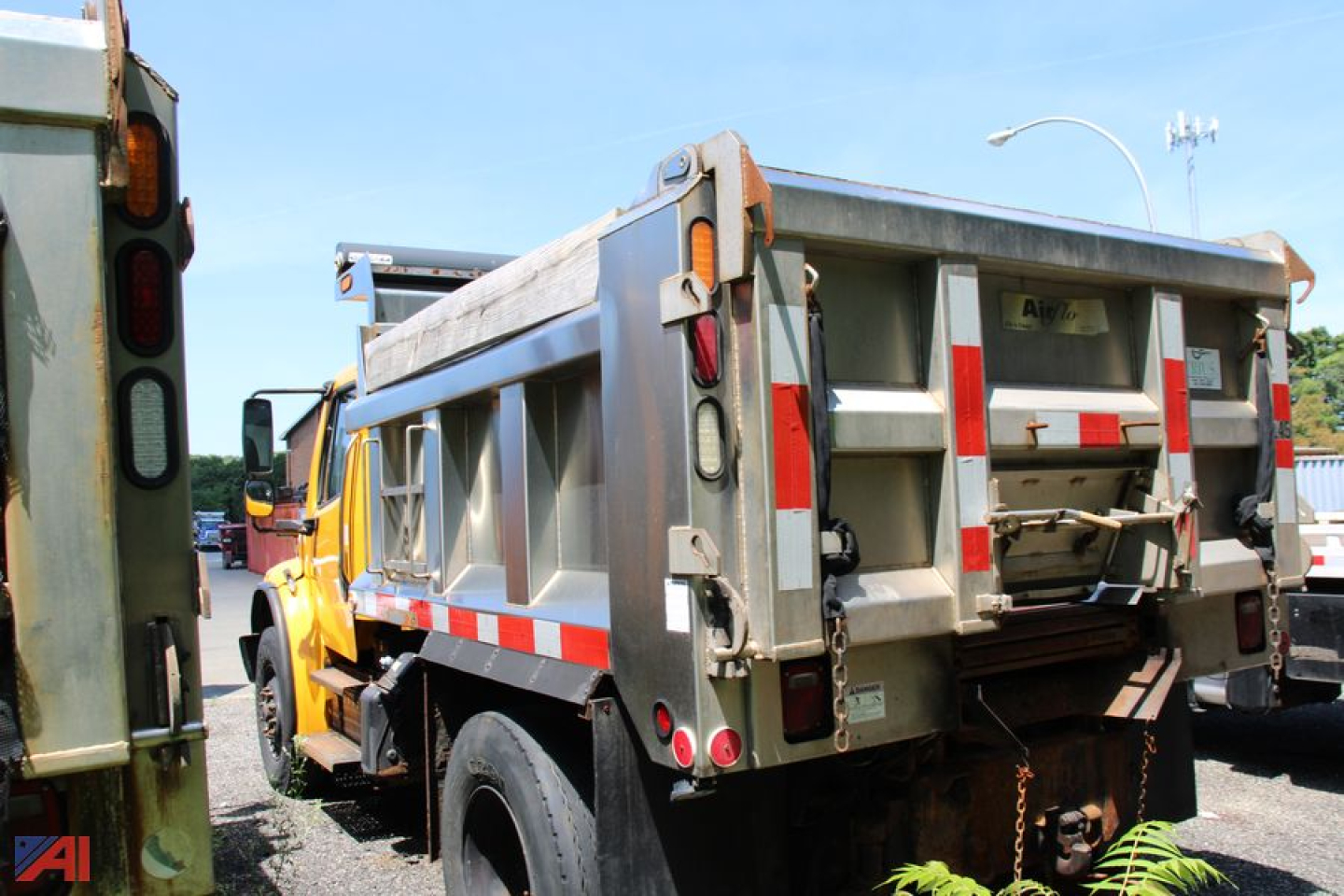 Truck dump bed with rear view showing Freightliner M2 106 dump truck rear with reflective stripes and tail lights.