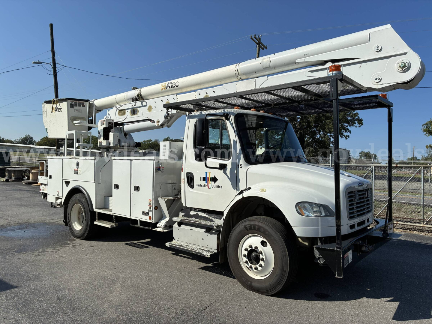Bucket truck on a Freightliner M2 106 chassis with an elevated boom and utility compartments visible.