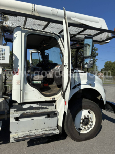 Cab interior and front section of a Freightliner M2 106 bucket truck showing open door and steps, windshield, and side mirror.