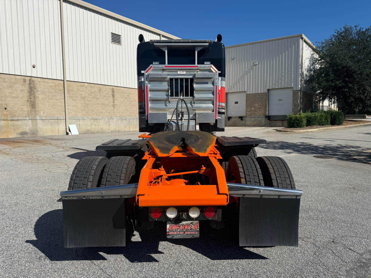 Kenworth W900L rear view showing fifth wheel and bumper with mud flaps and dual rear tires.