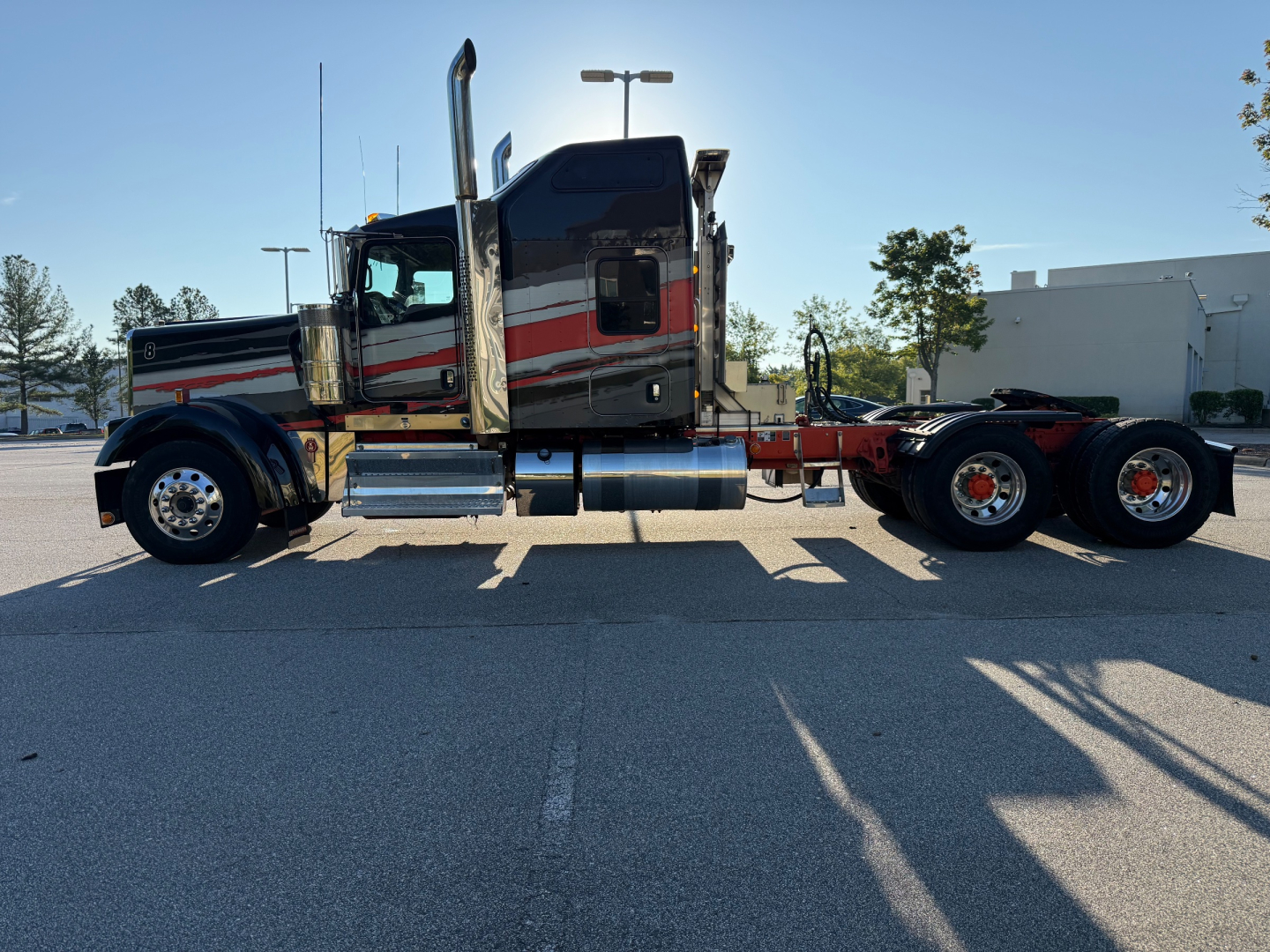 Kenworth W900L conventional sleeper truck side view showing chrome fuel tanks and dual rear axles, 2022 model year, used vehicle.