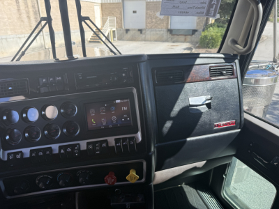 Kenworth W900L truck dash and interior view showing instrument cluster and center console with various controls.