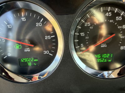 Dashboard of a Kenworth truck showing large tachometer and speedometer gauges with digital hour meter 12902.2 hrs and 78°F, and trip distance 9,526.1 miles, plus green indicators.