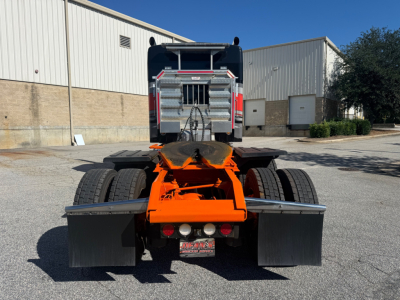 Kenworth W900L rear view showing fifth wheel and bumper with mud flaps and dual rear tires.