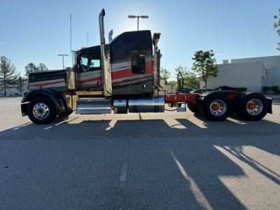 Kenworth W900L conventional sleeper truck side view showing chrome fuel tanks and dual rear axles, 2022 model year, used vehicle.