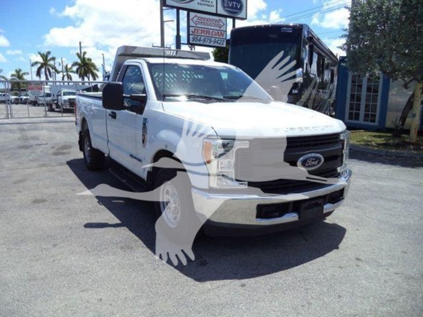 Ford F-250 pickup truck in a dealership lot with white body, front grille visible, with a watermark graphic overlay.