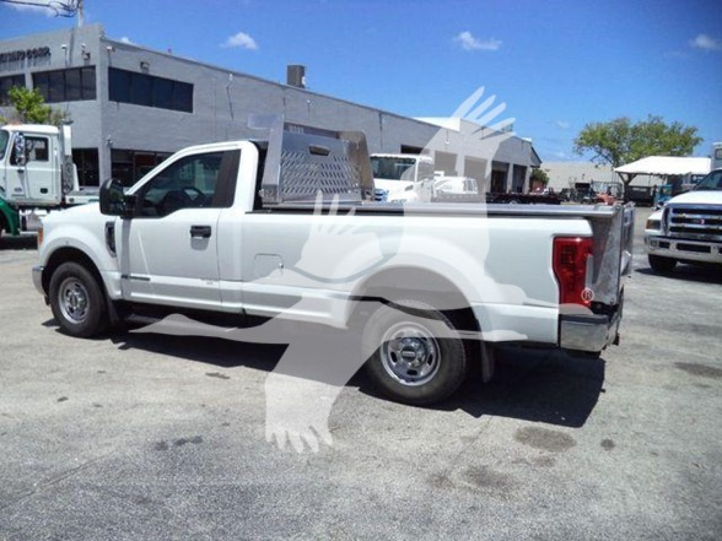 Ford F-250 pickup truck in white with utility bed and toolbox, side view showing cab, long bed, and aluminum toolbox.