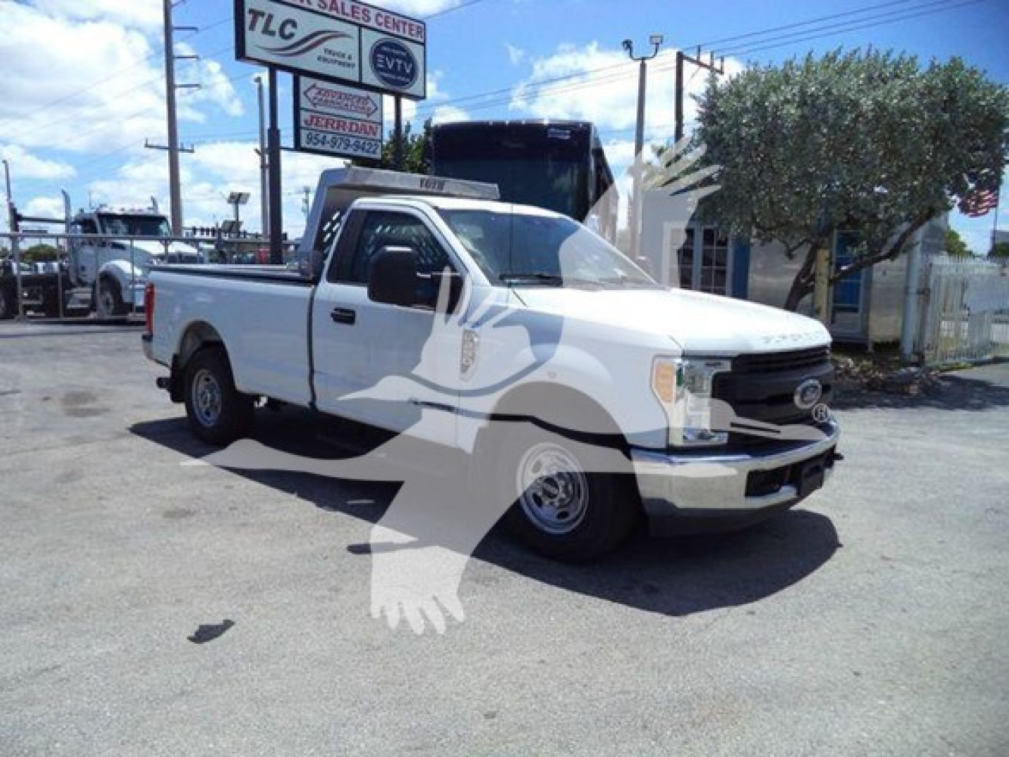 Ford F-250 pickup truck in a dealership lot, white cab and bed, front grille with Ford emblem, single cab, two-door, dump truck category sign visible in background.