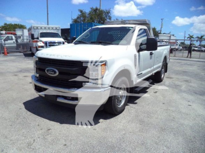 2017 Ford F-250 pickup truck in a lot, white with black grille and mirrors, front three-quarter view. Visible features: Ford emblem on grille, ‘F-250’ badge likely on side, large cab, cargo bed.