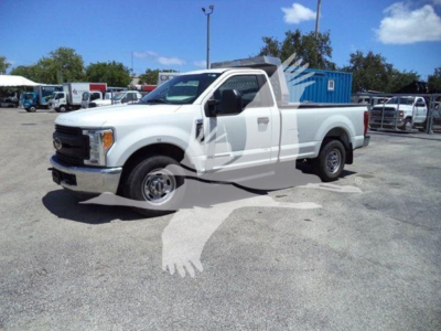 Truck in a dealership lot showing a white 2017 Ford F-250 regular cab pickup with an empty bed.