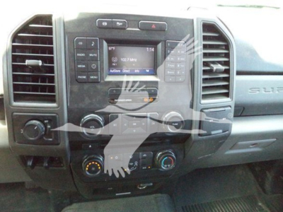 Dashboard of a 2017 Ford F-250 with center console controls, radio display showing 102.7 MHz, climate controls, and vents.