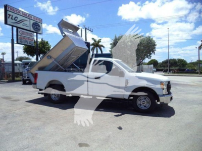 2017 Ford F250 dump bed truck in a used vehicle lot with hydraulic dump bed raised.
