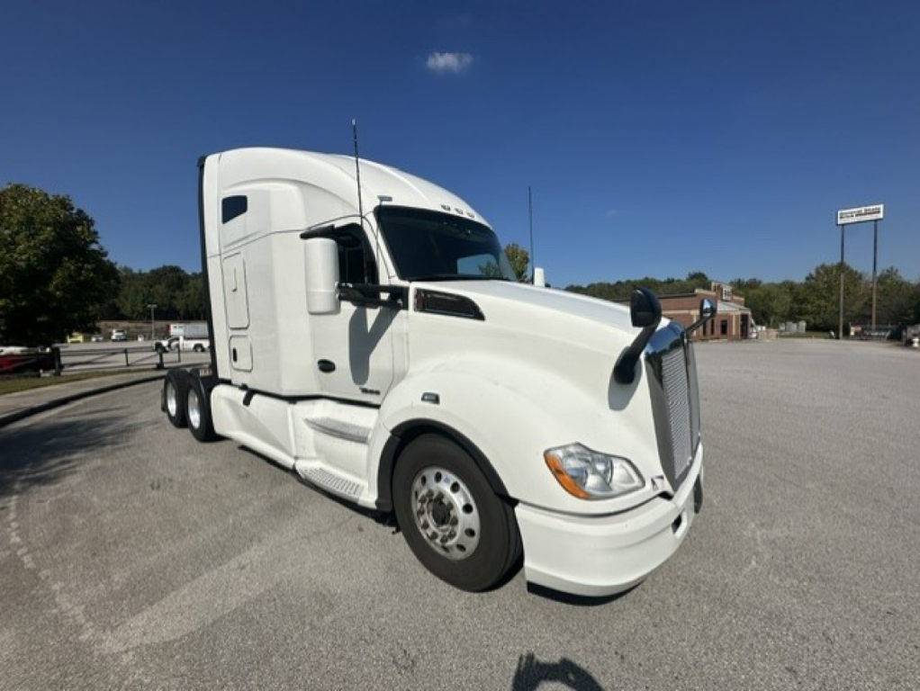 Kenworth T680 conventional sleeper tractor in white, front three-quarter view showing cab and dual rear axles.