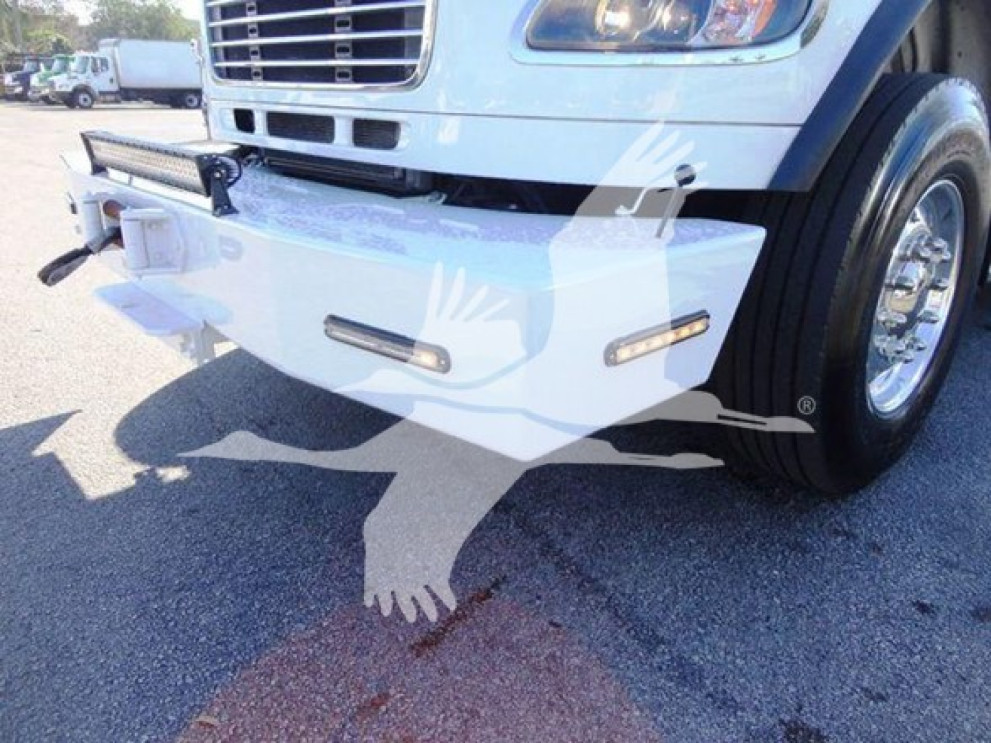 Front view of a Freightliner Business Class M2 106 truck showing a white bumper with integrated lights and winch mounting area.