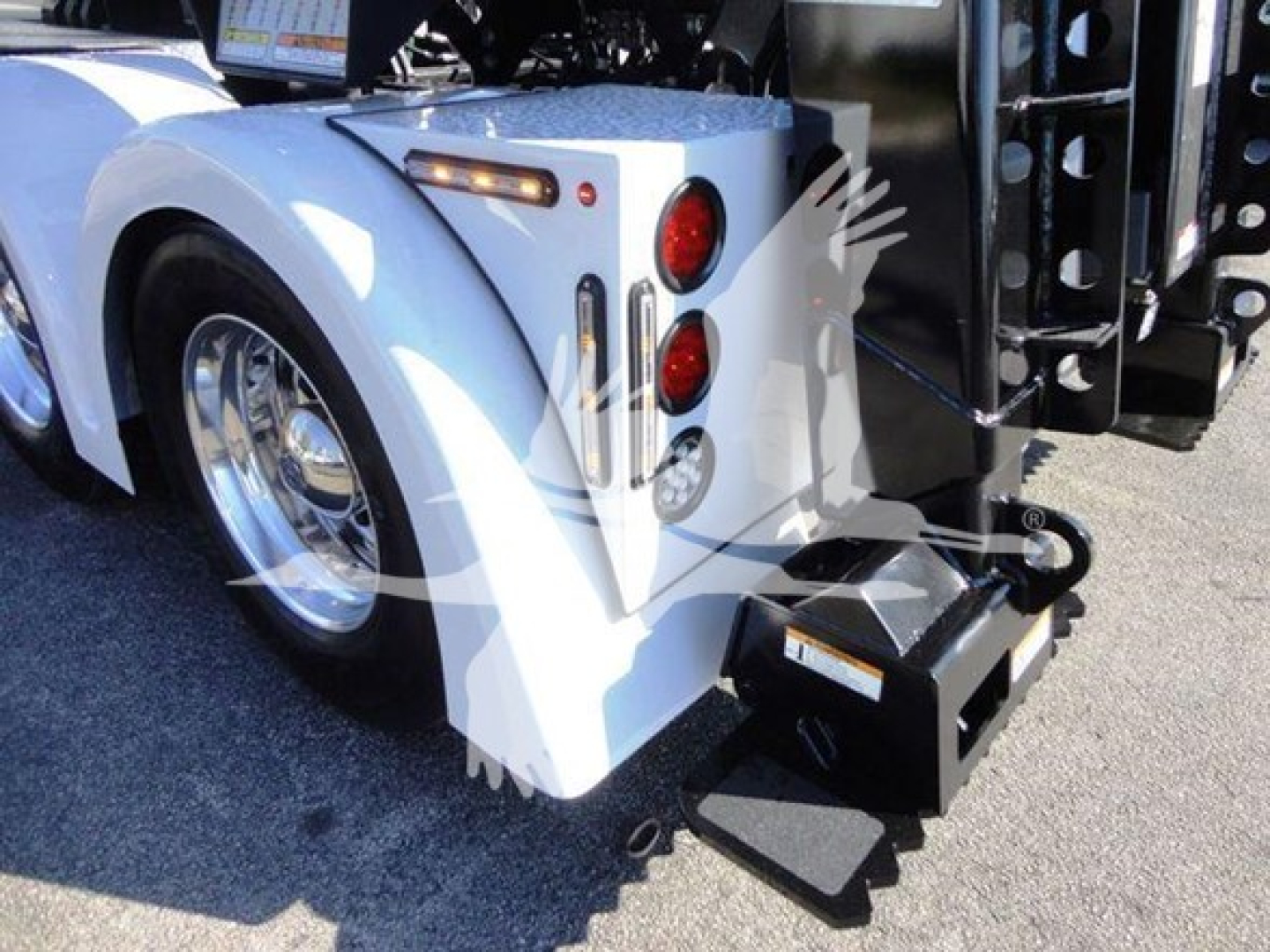 Freightliner Business Class M2 106 rear wheel area and winch attachment, white fender, dual red tail lights, metal step, and hydraulic winch housing visible.