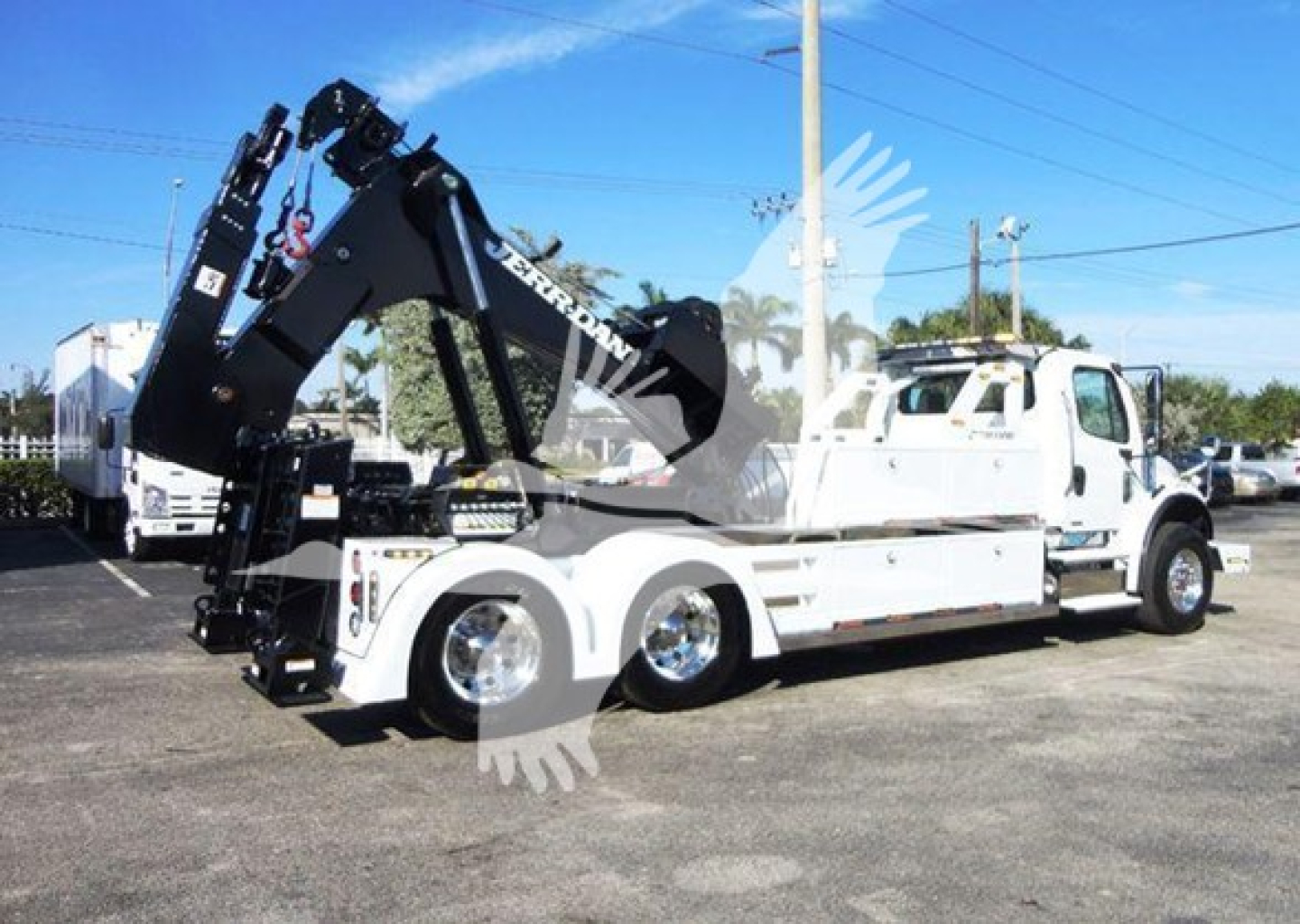 Freightliner Business Class M2 106 tow truck with hydraulic arm and winch, side view showing white cab and chassis.