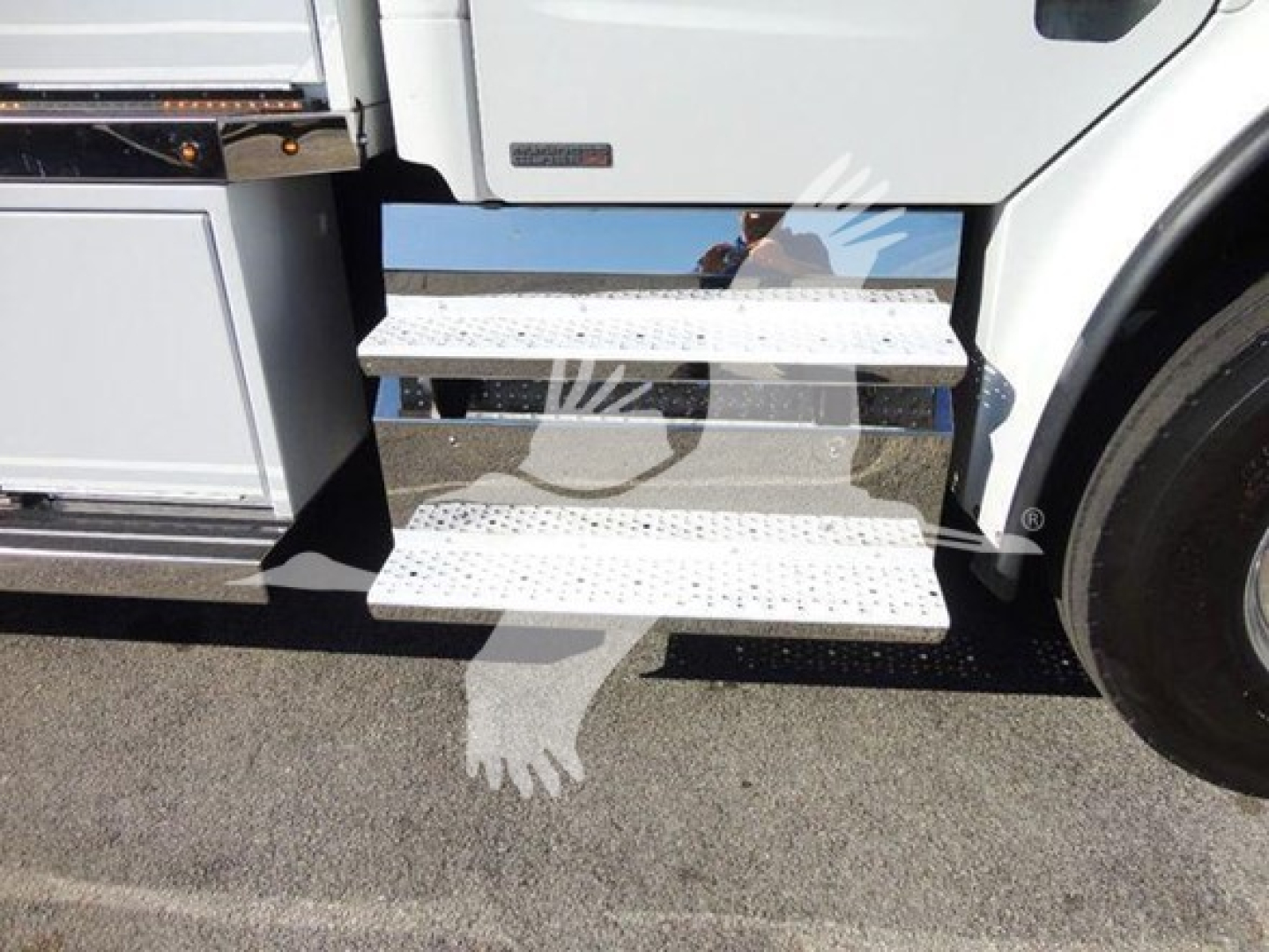 Freightliner Business Class M2 106 truck side view with metal steps and wheel visible.