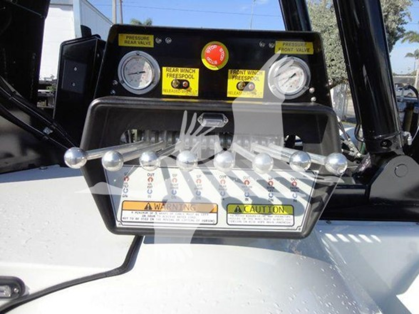 Equipment panel with dual gauges and winch controls on Freightliner Business Class M2 106. Front view of control panel with labels and switch handles.
