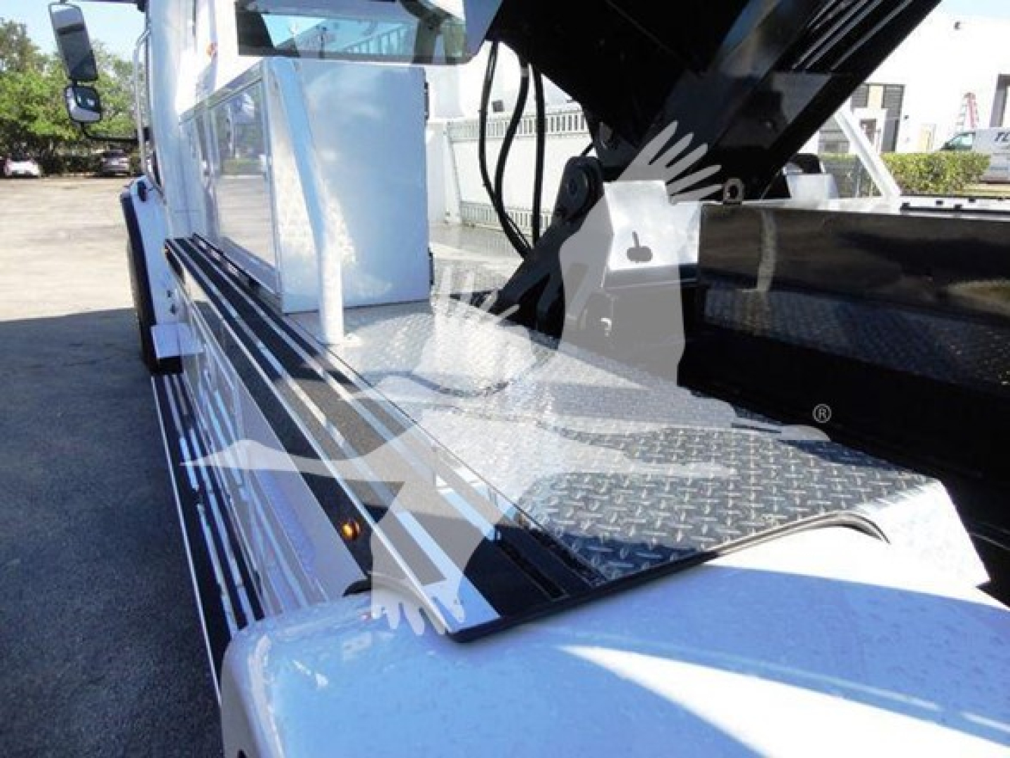 Freightliner Business Class M2 106 side profile showing chrome diamond plate step and winch equipment with black hydraulic arms.