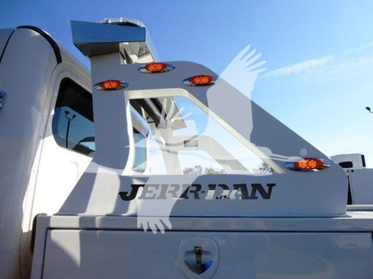 Front/side view of a Freightliner Business Class M2 106 winch truck showing a mounted winch assembly with orange clearance lights and Jerry-Ran branding.