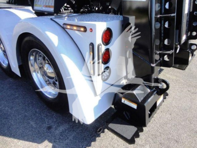 Freightliner Business Class M2 106 rear wheel area and winch attachment, white fender, dual red tail lights, metal step, and hydraulic winch housing visible.
