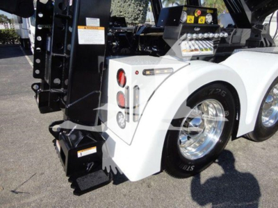 Freightliner Business Class M2 106 rear wheel and white fender, winch equipment visible with bumper lights and hydraulic components.