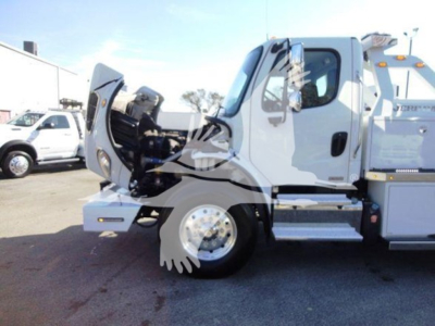 Cab and front wheel of a Freightliner Business Class M2 106 side view showing front bumper, open hood, and stepped chassis.