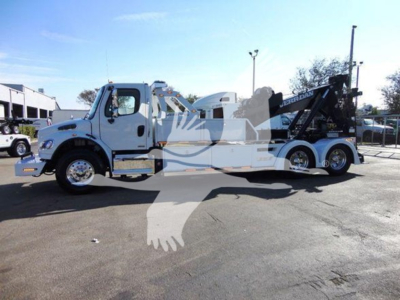 Freightliner Business Class M2 106 tow truck with heavy-duty winch and car trailer, side view showing wheel setup and equipment, stock TK9036.