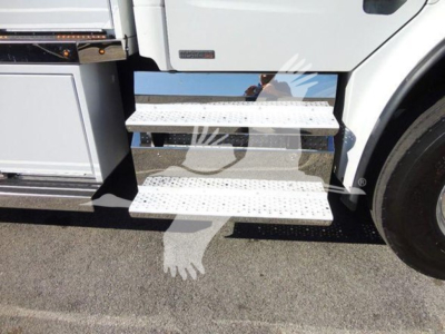 Freightliner Business Class M2 106 truck side view with metal steps and wheel visible.