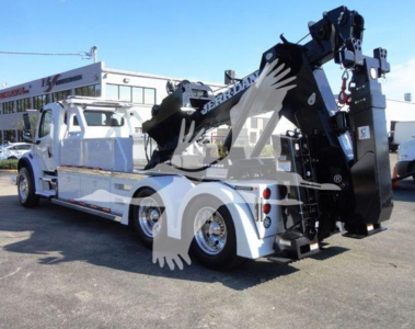 Truck with a heavy-duty tow crane on a white Freightliner Business Class M2 106 chassis, tow/winch equipment at rear, side view
