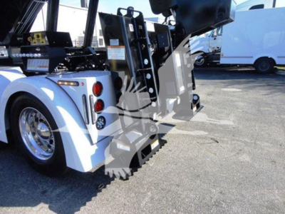 Winch truck rear detail of a 2012 Freightliner Business Class M2 106 showing hydraulic arms and rear body structure.