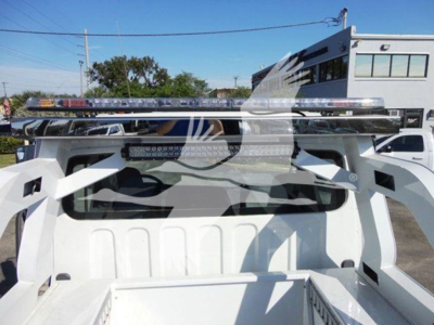 Truck bed with winch equipment mounted on Freightliner Business Class M2 106 chassis showing dual light bar and metal rails.