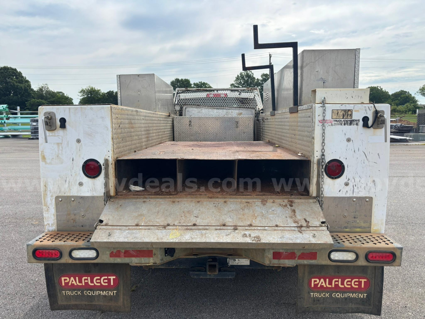 Truck bed of a 2012 Dodge Ram 550 service/utility vehicle showing tailgate with PalFect truck equipment labels and rear lights.