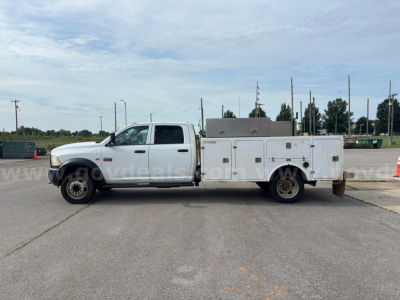 Side view of a white 2012 Dodge Ram 550 service truck with utility bed and compartments, showing stock number and VIN on vehicle in the listing photo.