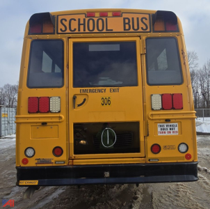 Front view of a yellow 2015 Freightliner B2B school bus with 'SCHOOL BUS' sign, emergency exit, rear lights, and a visible door area.