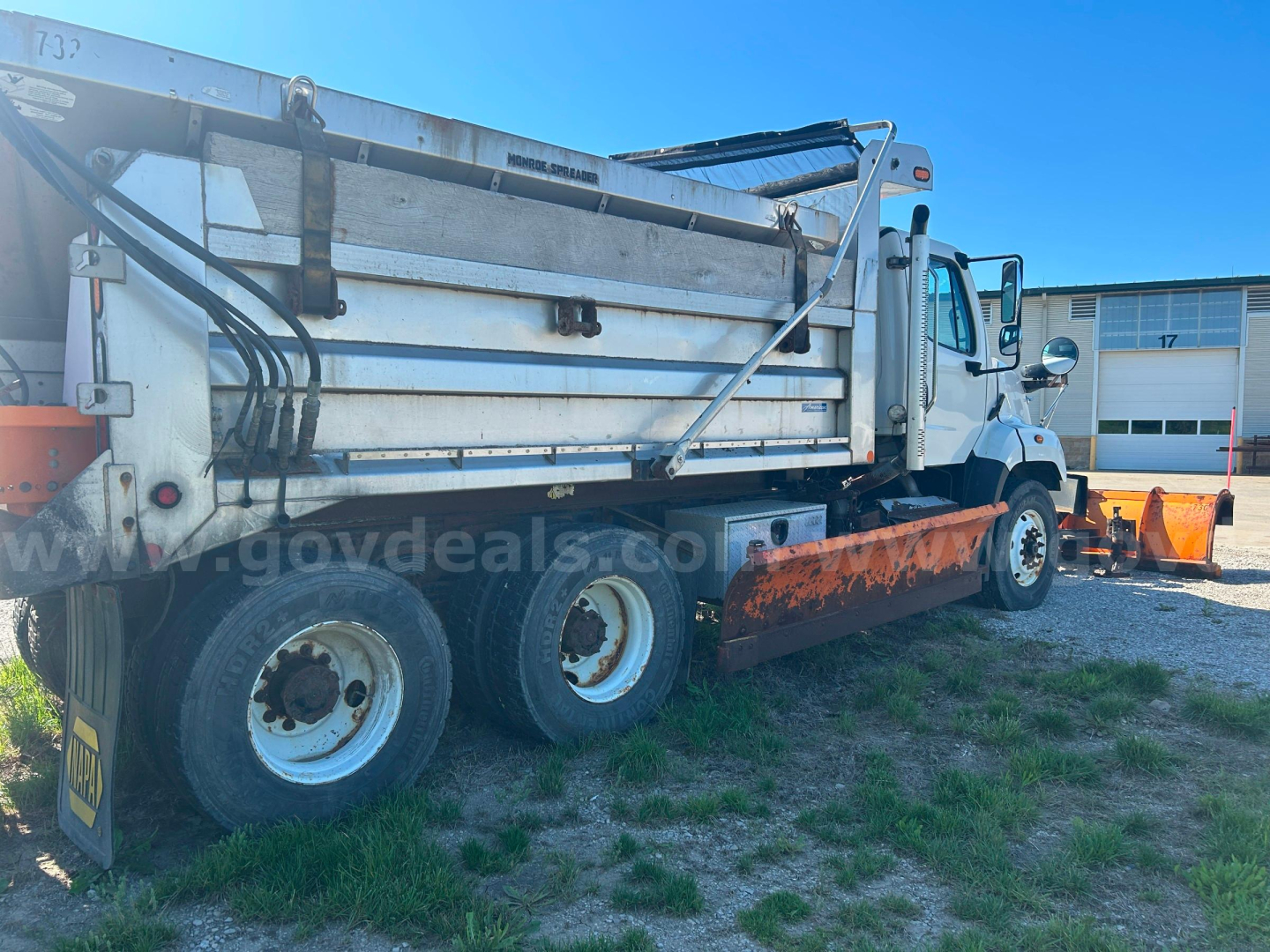 Freightliner 108SD dump truck side view showing plow equipment and rear dump bed.