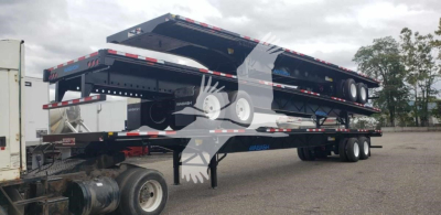 Wabash air slider trailer in side view with two-level flatbed sections and dual rear axles.